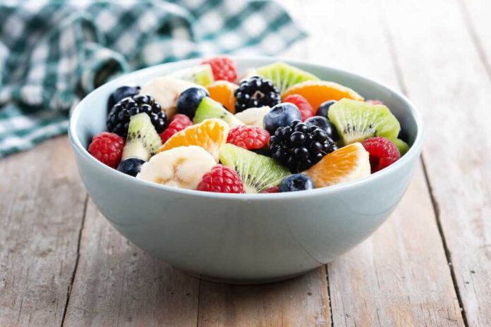 Fruit,Salad,In,A,Blue,Bowl,On,Wooden,Table