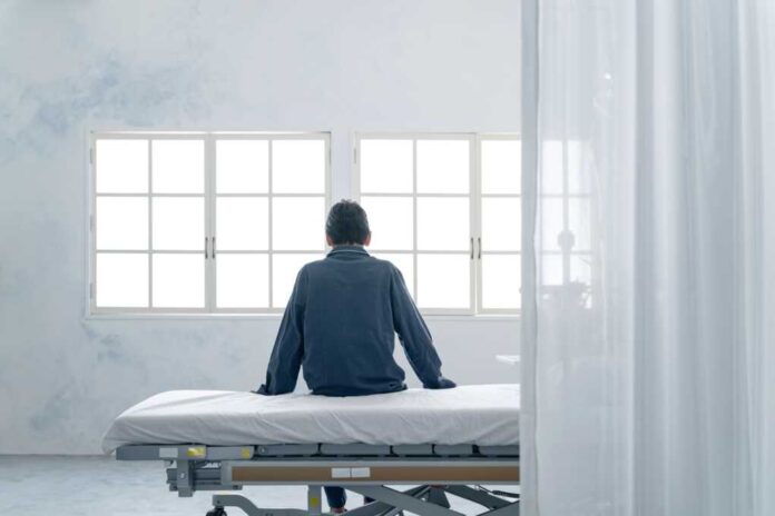 Depressed,Inpatient,Sitting,On,Bed,In,Hospital,Room
