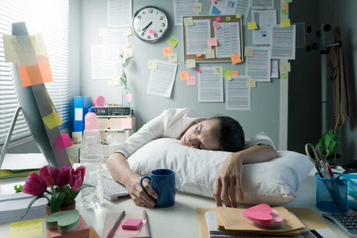 Tired,Businesswoman,At,Office,Desk,Waking,Up,With,Pillow,And