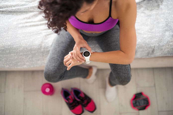 Woman,Checking,Her,Workout,Time,At,Home.