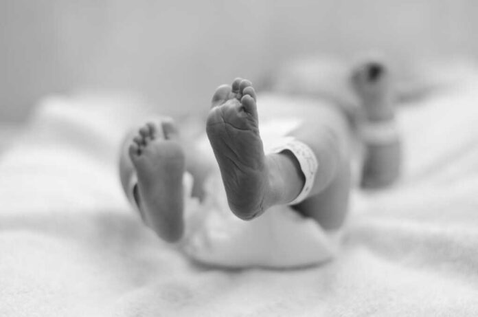 A,Black,And,White,Image,Of,A,Baby,Lying,On