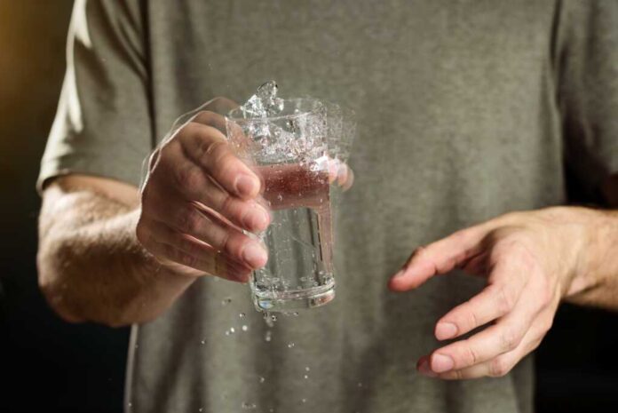A,Man,Holds,A,Glass,Of,Water,With,A,Shaking