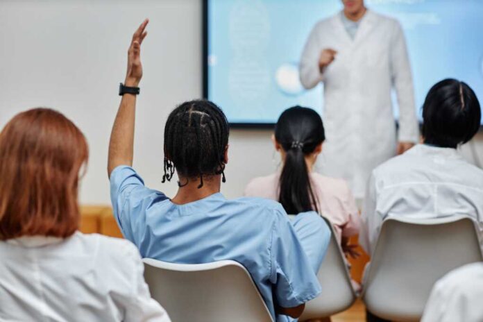 Back,View,At,Young,Black,Doctor,Raising,Hand,In,Audience