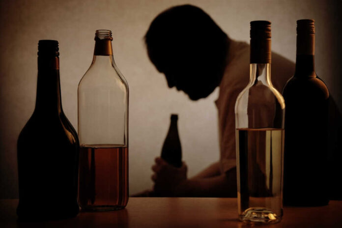 Silhouette,Of,A,Person,Drinking,Behind,Bottles,Of,Alcohol,With