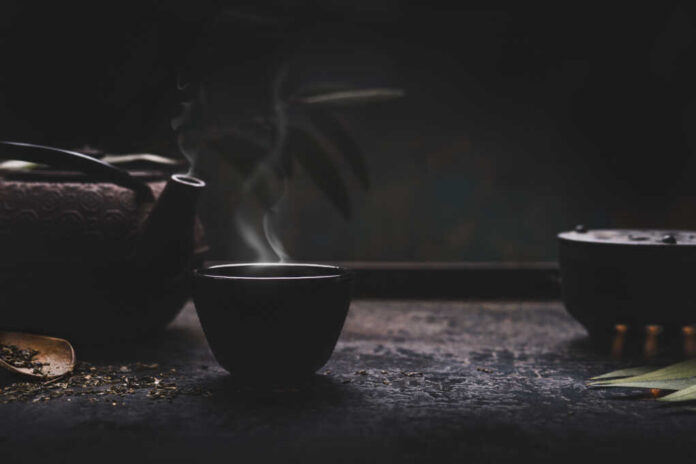 Dark,Tea,Background,With,Black,Iron,Asian,Teapot,And,Mug