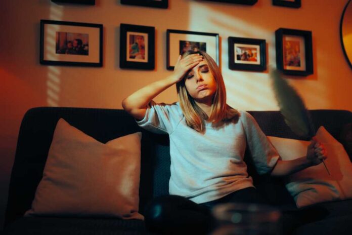 Woman,Feeling,Hot,Flashes,Fanning,Herself,With,A,Big,Leaf.