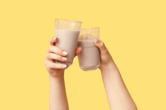 Female,Hands,With,Glasses,Of,Sweet,Chocolate,Milk,On,Yellow