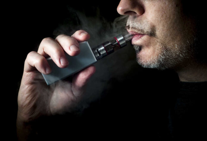 Man,Using,An,Advanced,Personal,Vaporizer,Or,E-cigarette,,Close,Up;
