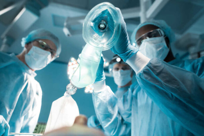 Bottom,View,Of,African,American,Anesthetist,Holding,Oxygen,Mask,Above