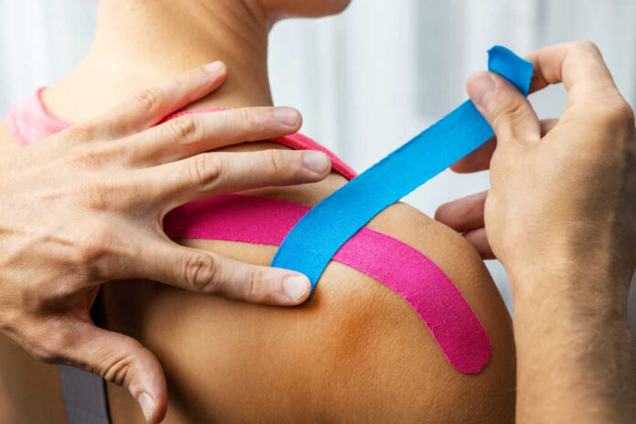 Kinesiology,-,Physiotherapist,Taping,Injured,Patient,Shoulder,With,Kinesio,Tape