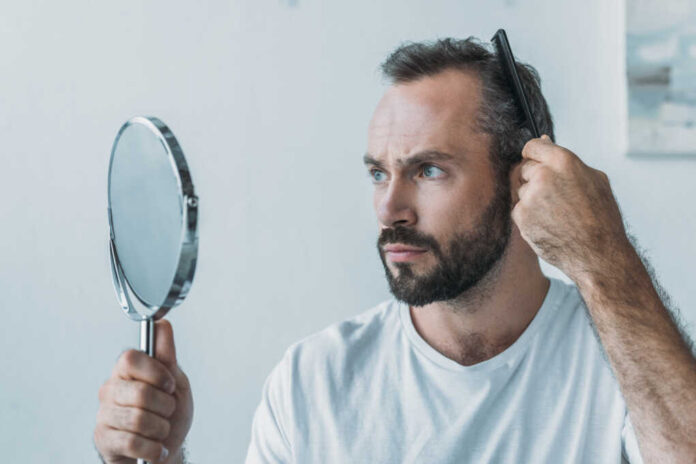 Bearded,Middle,Aged,Man,Combing,Hair,And,Looking,At,Mirror,