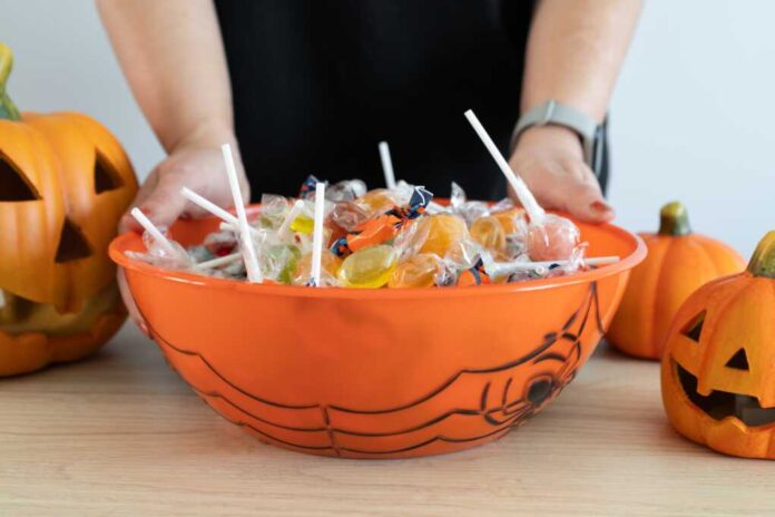 Woman,Holding,A,Halloween,Candy,Bowl,Filled,With,Sweets,For