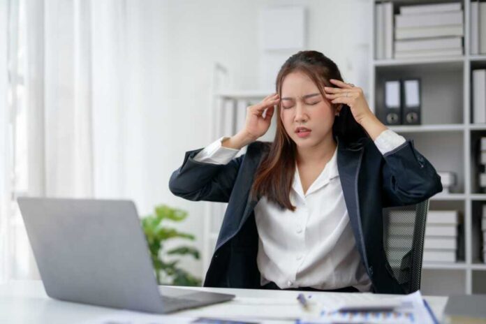 Stressed,Businesswoman,In,Office,With,Headache,,Massaging,Temples,While,Working