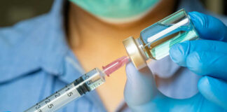 Healthcare professional preparing a syringe from a vial