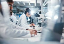 Inflammation’s Hidden Off Switch Uncovered Scientists working in a laboratory with microscopes and test tubes