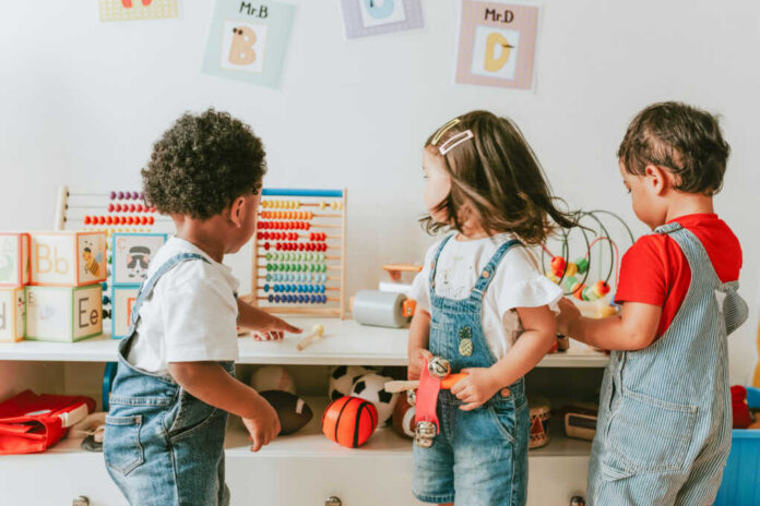 shutterstock1240622437jpg Three children engaged in play with educational toys in a colorful classroom