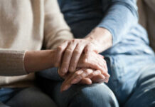 Close-up of two hands gently holding each other, symbolizing support and affection