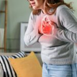 Woman holding her chest in discomfort with a heart illustration