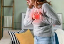 Heart Disease Detection Mistake? Check This Marker Woman holding her chest in discomfort with a heart illustration
