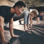 Group of individuals performing push-ups in a gym