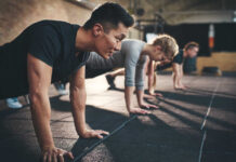 Group of individuals performing push-ups in a gym
