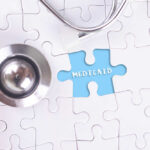 A stethoscope next to a puzzle piece labeled 'Medicaid'