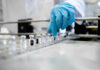 A healthcare professional in a lab preparing vaccine vials