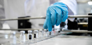 A healthcare professional in a lab preparing vaccine vials