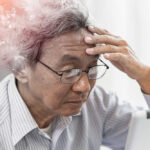 Elderly man looking stressed while using a digital device