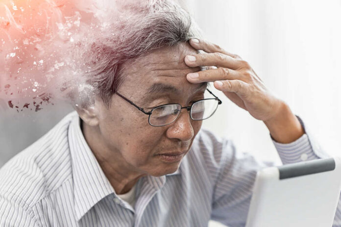 Elderly man looking stressed while using a digital device