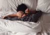 The Sleep Hack Hiding in Plain Sight Child lying in bed with hands over ears
