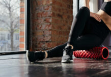Person using a foam roller for stretching in a fitness studio