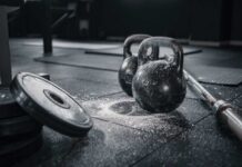 Kettlebells and weights on a gym floor with chalk dust