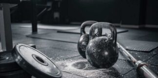 Kettlebells and weights on a gym floor with chalk dust