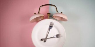 An alarm clock with a plate and two forks arranged in a creative design