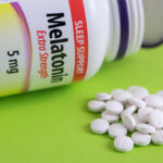 Sleep Myths Debunked: What You Need to Know Bottle of melatonin tablets with some pills spilled on a green surface