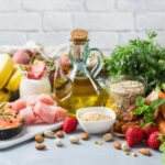 Fruits That Could Rewrite Diabetes Management A variety of fresh foods including fruits, vegetables, and oils arranged on a table
