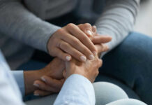 Surprising Handshake Study: Mental Health Red Flag Two hands clasped together in a comforting gesture