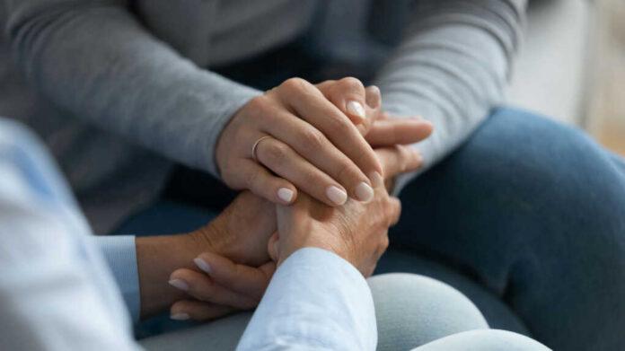 Two hands clasped together in a comforting gesture