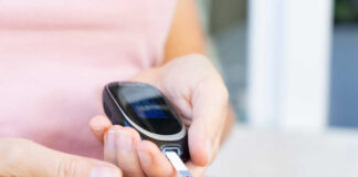 Person using a blood glucose meter to check their blood sugar level