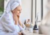 The 5-10 Shave Myth Woman in a bathrobe with a towel on her head, smiling at her reflection in a mirror