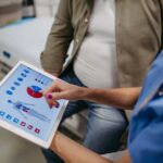 Early-Onset Cancer Mystery Baffles Experts Nurse showing a patient health data on a tablet
