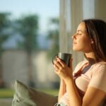 Caffeine Turns on You: When Too Much Is Bad Woman enjoying a cup of coffee in a sunlit room