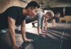 Protein Or Exercise: Which Is Better For Muscle Health? Group of individuals performing push-ups in a gym