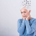 Elderly woman with a unique hairstyle made of puzzle pieces, looking thoughtful