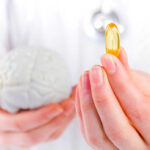 Brain Supplement’s Hidden Risk A medical professional holding a brain model in one hand and a yellow supplement capsule in the other