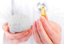 Brain Supplement’s Hidden Risk A medical professional holding a brain model in one hand and a yellow supplement capsule in the other