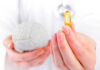 Brain Shrink Alarm: One Vitamin Deficiency Flags Trouble A medical professional holding a brain model in one hand and a yellow supplement capsule in the other