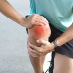 Stanford’s Bold Move Rewrites Arthritis Playbook Athlete holding their knee in pain while exercising outdoors