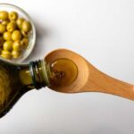 Diabetes Trigger Lurking In Everyday Diet Fat? Pouring olive oil from a bottle into a wooden spoon